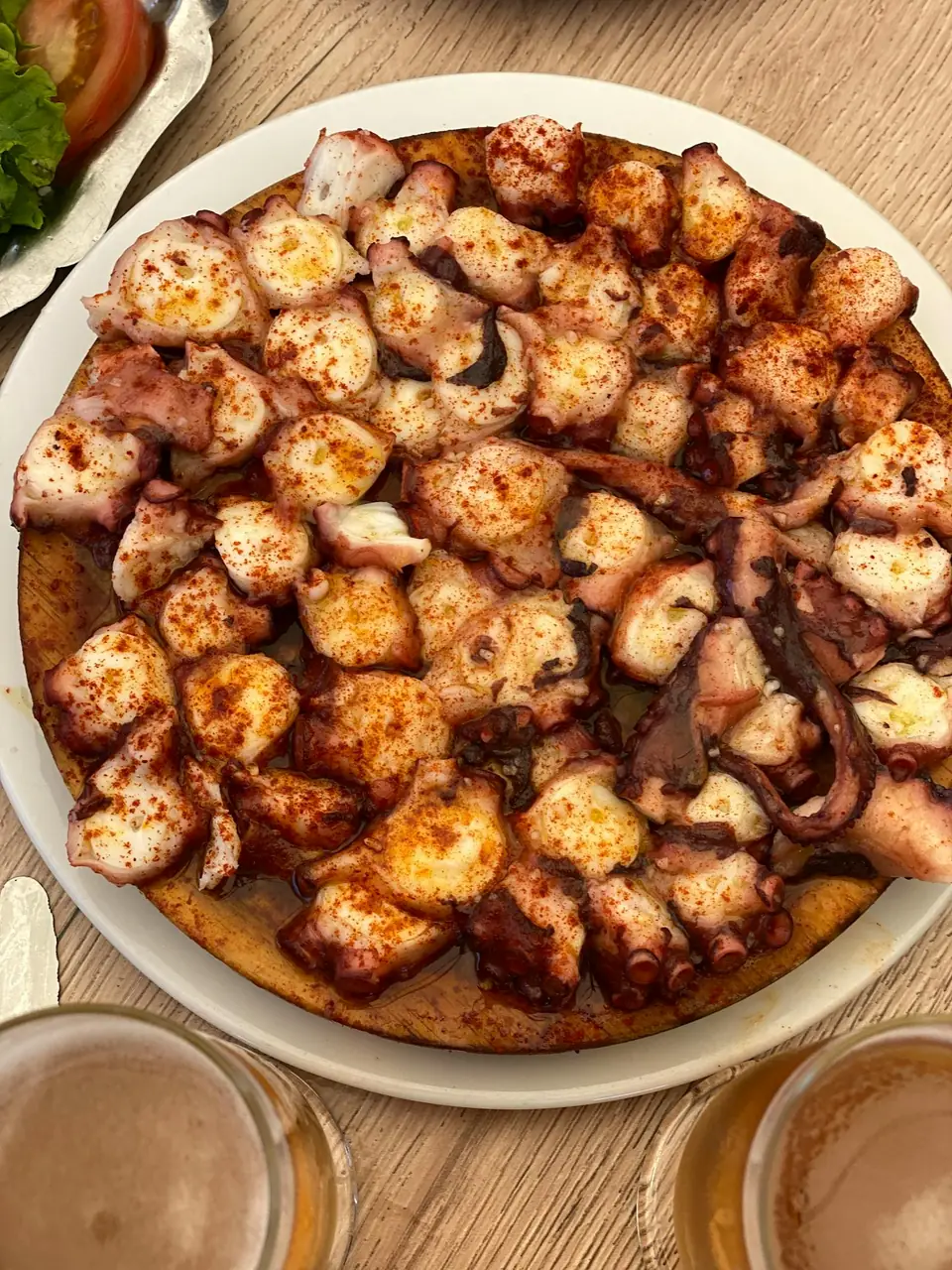 Pulpo a feira gallego con pimentón y aceite de oliva sobre tabla de madera